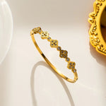 18K gold plated crystal clover station bangle by Biya Accessoires.