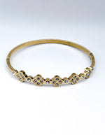 Gold bracelet with diamond accents on a white background