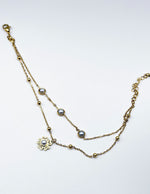 Waterproof gold layered pearl drop botanical charm bracelet for women Dubai.