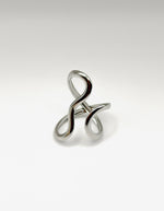 Silver ring with a twisted design on a light gray background