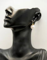 Close up of elegant imitation jewelry uae featuring a gold hoop and large round pearl.
