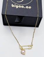 Biya Accessoires 18K gold plated safety pin necklace with pink heart crystal.