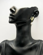 Close up of elegant imitation jewelry uae featuring a pavé crystal bird and large faux pearl.