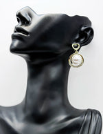 Close up of imitation jewelry uae statement drops featuring pavé stones and pearl centers.
