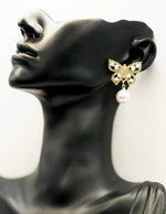 Close up of imitation jewelry uae statement studs featuring pavé stones and pearls.
