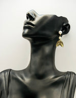 Biya Accessoires gold mermaid tail and double pearl drop earrings.