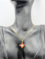 Gold necklace with a red flower pendant on a mannequin