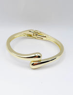 Gold bracelet on a light gray background