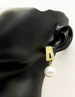 Sparkling crystal and pearl earrings resting on an elegant display.