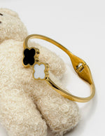 18K gold plated black and white dual clover bypass bangle by Biya Accessoires.