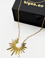 Edgy gold statement necklace with radiant spikes on display.