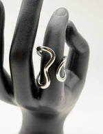 Silver ring on a black mannequin hand against a white background