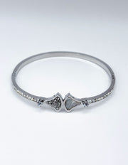Silver bracelet with heart-shaped charms on a light gray background