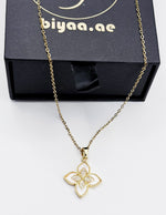 Modern luxury gold and pavé crystal quatrefoil statement necklace.