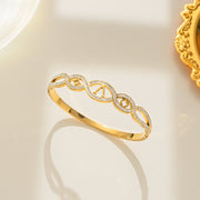 Gold bracelet with intricate design on a light background