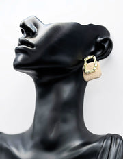 Close up of imitation jewelry uae urban studs featuring textured gold and grid pattern.