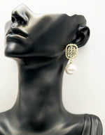 Close up of imitation jewelry uae statement drops featuring crystal studs and large pearl drops.