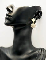Close up of imitation jewelry uae statement drops featuring champagne resin and pavé stones.
