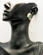 Earring on a black mannequin head with a white background