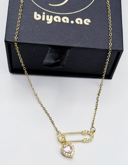 Biya Accessoires 18K gold plated safety pin necklace with pink heart crystal.