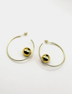 Close up of elegant imitation jewelry uae featuring oversized hoops and polished gold balls.