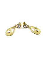 Close up of elegant imitation jewelry uae featuring an open gold frame lined with small pearls and a teardrop center.