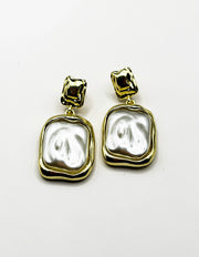 Close up of imitation jewelry uae statement drops featuring textured metal and pearlescent resin.