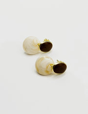Biya Accessoires mustard and marbled white resin drop earrings.