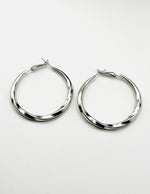 Biya Accessoires silver oversized twisted hoop earrings.