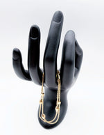 Luxury double strand gold geometric bracelet by Biya Accessoires on modeled wrist.