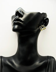 Gold hoop earrings on a black mannequin bust against a white background