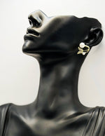 Close up of elegant imitation jewelry uae featuring a pavé crystal butterfly and faux pearls.