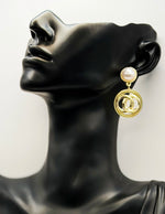 Close up of elegant imitation jewelry uae featuring a pearl stud and textured gold circles.