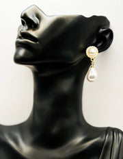 Pearl earring on a black mannequin head against a white background