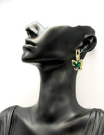 Close up of imitation jewelry uae statement drops featuring emerald pavé wings.
