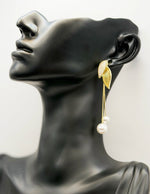 Close up of imitation jewelry uae statement drops featuring glossy leaves and snake chains.
