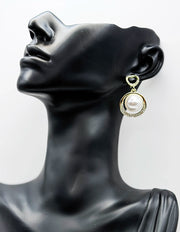 Close up of imitation jewelry uae statement drops featuring pavé stones and pearl centers.