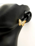 Close up of imitation jewelry uae statement studs featuring butterfly wing textures.