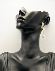 Close up of premium hypoallergenic imitation jewelry featuring a crystal arc and chain drop.