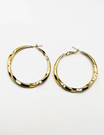 Biya Accessoires gold oversized twisted hoop earrings.