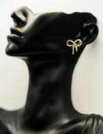 Biya Accessoires gold textured bow stud earrings.