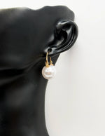 Close-up of premium hypoallergenic imitation jewelry featuring a round pearl and gold design.