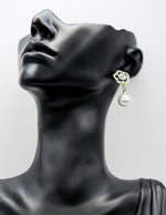 Close up of elegant imitation jewelry uae featuring a black enamel rose stud and faux pearl.