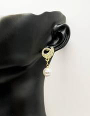 Close up of elegant imitation jewelry uae featuring a pavé crystal bird and large faux pearl.