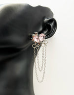 Close up of imitation jewelry uae statement dangles featuring triple silver chains.