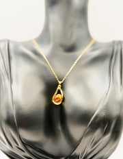 Waterproof gold pear shaped necklace for women on white silk.