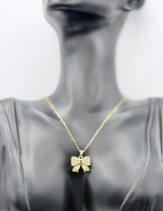 Waterproof gold ribbon bow pendant necklace on silk Dubai.