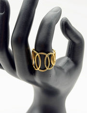 Gold ring on a black mannequin hand against a white background