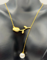 Model wearing an elegant gold lariat drop necklace with pearls in the UAE.