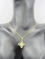 Gold necklace with a floral pendant on a mannequin
